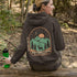 This graphic hoodie features a majestic deer standing against a wilderness backdrop— mountains, towering pines, a glowing moon, and a star-filled night sky.