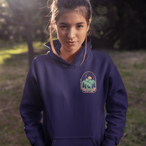 This graphic hoodie features a majestic deer standing against a wilderness backdrop— mountains, towering pines, a glowing moon, and a star-filled night sky.