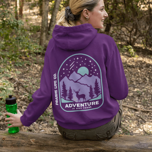 This hoodie features a graphic of a deer standing in the mountains beneath a moonlit sky, everything we love about the quiet magic of the wilderness.