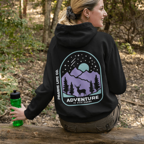 This hoodie features a graphic of a deer standing in the mountains beneath a moonlit sky, everything we love about the quiet magic of the wilderness.