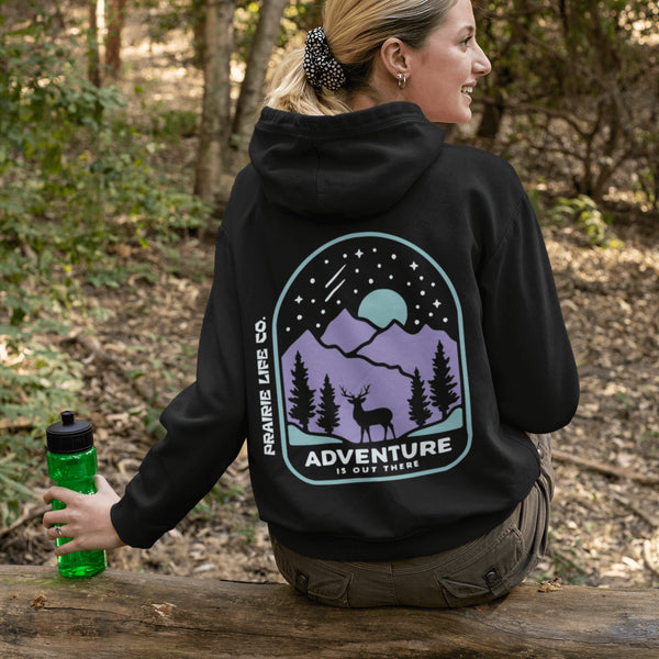 This hoodie features a graphic of a deer standing in the mountains beneath a moonlit sky, everything we love about the quiet magic of the wilderness.