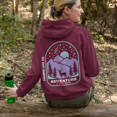 This hoodie features a graphic of a deer standing in the mountains beneath a moonlit sky, everything we love about the quiet magic of the wilderness.