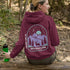 This hoodie features a graphic of a deer standing in the mountains beneath a moonlit sky, everything we love about the quiet magic of the wilderness.