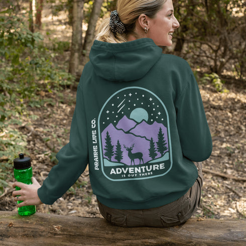 This hoodie features a graphic of a deer standing in the mountains beneath a moonlit sky, everything we love about the quiet magic of the wilderness.