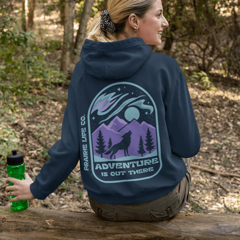 This hoodie features a wolf howling at the moon, rugged mountains, towering pines, and a breathtaking starry sky illuminated by dancing northern lights.
