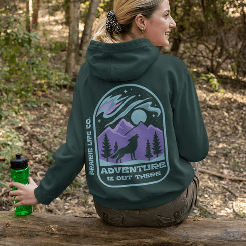 This hoodie features a wolf howling at the moon, rugged mountains, towering pines, and a breathtaking starry sky illuminated by dancing northern lights.