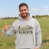 person wearing Alberta prairie life hoodie with farm and landscape design outdoors