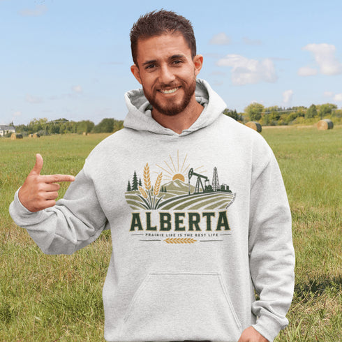 person wearing Alberta prairie life hoodie with farm and landscape design outdoors