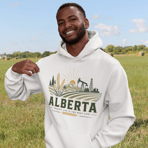 person wearing Alberta prairie life hoodie with farm and landscape design outdoors