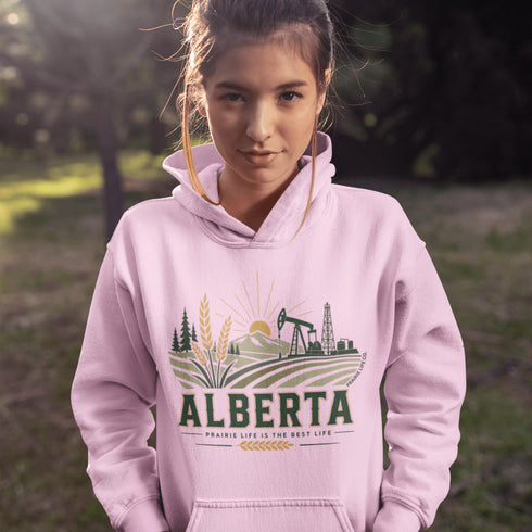 person wearing Alberta prairie life hoodie with farm and landscape design outdoors