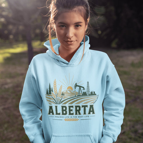 person wearing Alberta prairie life hoodie with farm and landscape design outdoors