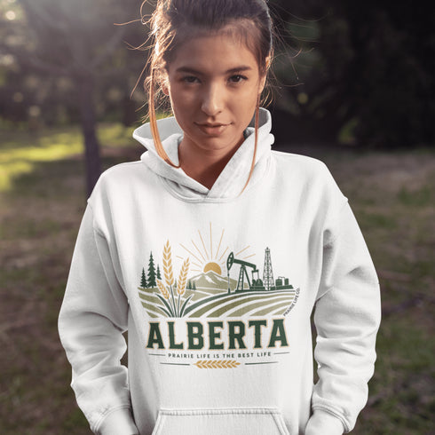 person wearing Alberta prairie life hoodie with farm and landscape design outdoors
