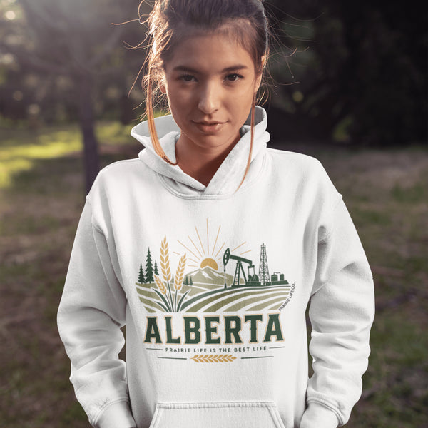 person wearing Alberta prairie life hoodie with farm and landscape design outdoors