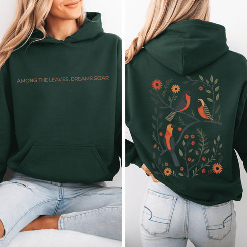Wrap yourself in the charm of nature with our Among the Leaves Hoodie, a wearable piece of folk art that celebrates the harmony of birds, branches, and blooms.