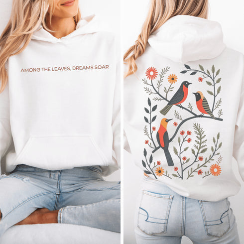 Wrap yourself in the charm of nature with our Among the Leaves Hoodie, a wearable piece of folk art that celebrates the harmony of birds, branches, and blooms.