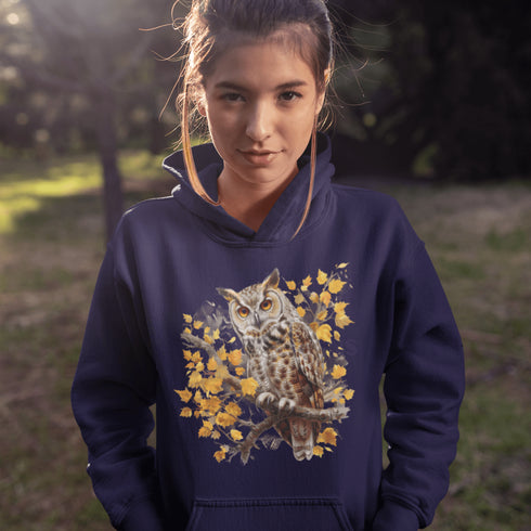 This hoodie features a beautifully detailed owl perched on a branch, surrounded by a scattering of warm-toned autumn leaves.