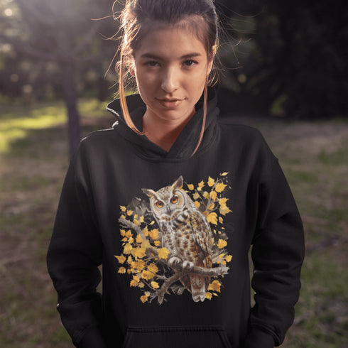 This hoodie features a beautifully detailed owl perched on a branch, surrounded by a scattering of warm-toned autumn leaves.