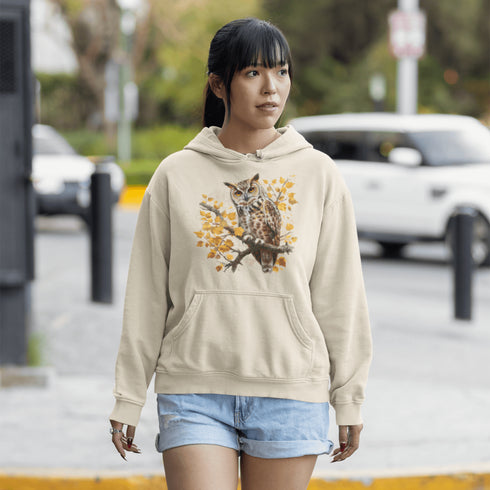 This hoodie features a beautifully detailed owl perched on a branch, surrounded by a scattering of warm-toned autumn leaves.