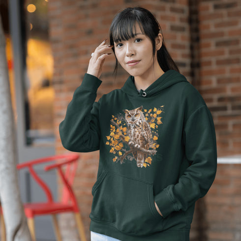 This hoodie features a beautifully detailed owl perched on a branch, surrounded by a scattering of warm-toned autumn leaves.