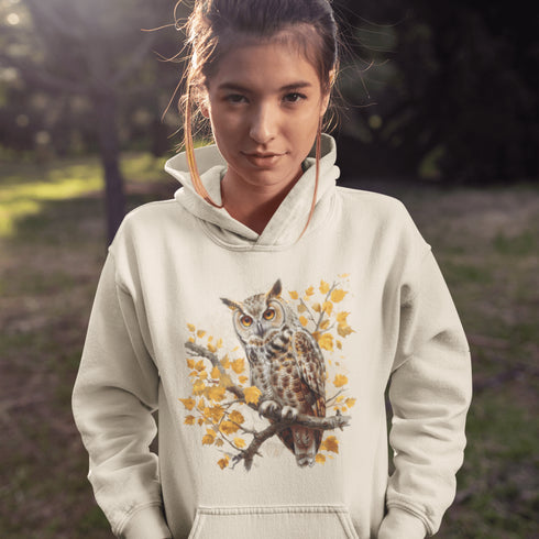 This hoodie features a beautifully detailed owl perched on a branch, surrounded by a scattering of warm-toned autumn leaves.