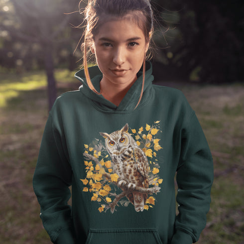 This hoodie features a beautifully detailed owl perched on a branch, surrounded by a scattering of warm-toned autumn leaves.