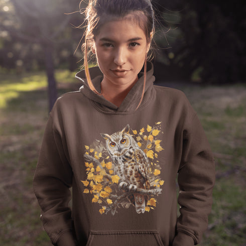 This hoodie features a beautifully detailed owl perched on a branch, surrounded by a scattering of warm-toned autumn leaves.