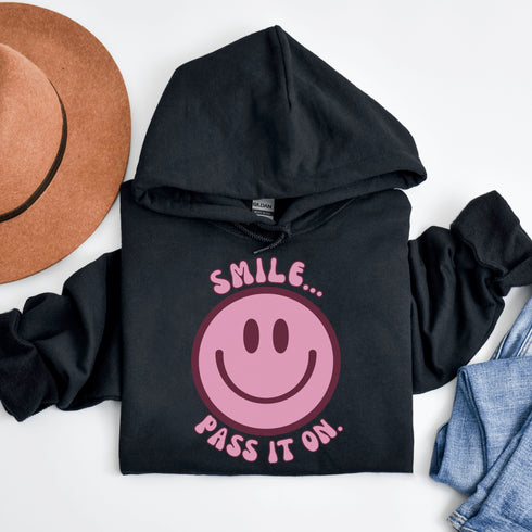 Introducing the ultimate mood booster in fabric form: the "Smile…Pass It On" Happy Face Hoodie! This isn't just any ordinary hoodie; it's a wearable ray of sunshine, guaranteed to spread joy, high-fives, and possibly even spontaneous dance-offs wherever you go.