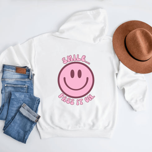Introducing the latest must-have in your wardrobe that's guaranteed to turn frowns upside down: the Happy Face Hoodie emblazoned with the cheer-spreading command, "Smile...Pass it on." This isn't just any ordinary hoodie; it's your ticket to becoming a walking, talking (and very cozy) ambassador of joy!