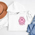 Introducing the latest must-have in your wardrobe that's guaranteed to turn frowns upside down: the Happy Face Hoodie emblazoned with the cheer-spreading command, "Smile...Pass it on." This isn't just any ordinary hoodie; it's your ticket to becoming a walking, talking (and very cozy) ambassador of joy!