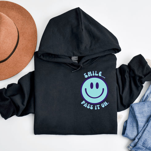 Introducing the latest must-have in your wardrobe that's guaranteed to turn frowns upside down: the Happy Face Hoodie emblazoned with the cheer-spreading command, "Smile...Pass it on." This isn't just any ordinary hoodie; it's your ticket to becoming a walking, talking (and very cozy) ambassador of joy!