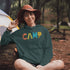 Introducing our vibrant and adventurous camping hoodie! Featuring bold and colorful "Camp" letters adorned with charming camping icons cut out, this shirt is perfect for outdoor enthusiasts and nature lovers alike.