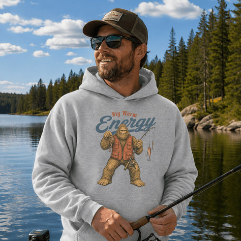 Unisex Gildan 18500 hoodie featuring a vintage-style Bigfoot fishing graphic with the phrase "Big Worm Energy," available in multiple colors.