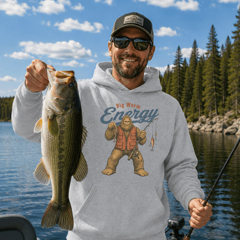 Unisex Gildan 18500 hoodie featuring a vintage-style Bigfoot fishing graphic with the phrase "Big Worm Energy," available in multiple colors.