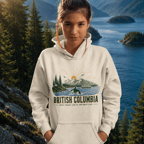 Person wearing a hoodie with a British Columbia design in front of a scenic lake and mountains.