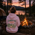 Vintage-inspired outdoor hoodie featuring a matching left chest graphic and large camping-themed back graphic, displayed in a lifestyle mockup inspired by campfires, camping, hiking, and outdoor adventures.