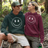 Introducing the latest in outdoor fashion and forest friendliness: the "Tree-mendous Smiles Hoodie"! This isn't just any hoodie; it's your ticket to becoming the most smiley face in the wild. With a dazzling happy face emblazoned on the front, you're set to spread joy among the trees, the birds, and even the most stubborn of rocks.