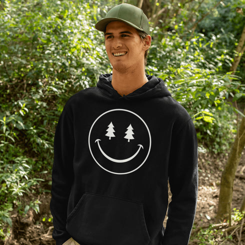 Introducing the latest in outdoor fashion and forest friendliness: the "Tree-mendous Smiles Hoodie"! This isn't just any hoodie; it's your ticket to becoming the most smiley face in the wild. With a dazzling happy face emblazoned on the front, you're set to spread joy among the trees, the birds, and even the most stubborn of rocks.