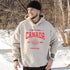 Woman wearing white Canada Always Strong hoodie with red maple leaf graphic and “Est. 1867” design, styled outdoors in a natural setting