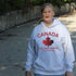 Canadian “True North Strong and Free” hoodie in light grey with red maple leaf graphic, cozy unisex Canada pride sweatshirt