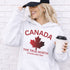 White Canada hoodie with bold maple leaf design and “True North Strong and Free” text, unisex Canadian sweatshirt