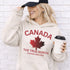 White Canada hoodie with bold maple leaf design and “True North Strong and Free” text, unisex Canadian sweatshirt