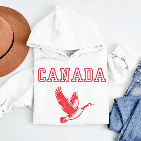 This hoodie celebrates the Canadian goose, wings spread wide, flying across Canada (and probably plotting its next lawn invasion).