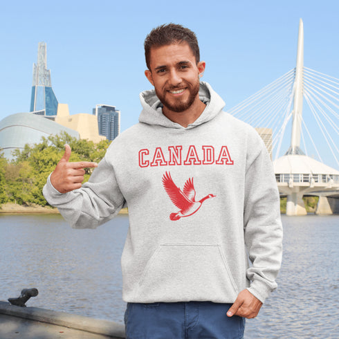 This hoodie celebrates the Canadian goose, wings spread wide, flying across Canada (and probably plotting its next lawn invasion).