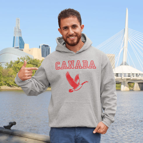 This hoodie celebrates the Canadian goose, wings spread wide, flying across Canada (and probably plotting its next lawn invasion).