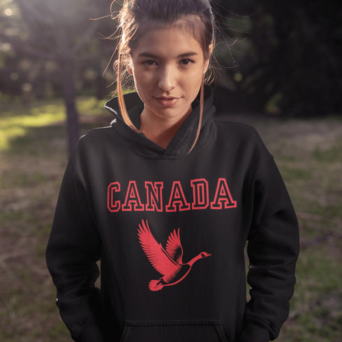 This hoodie celebrates the Canadian goose, wings spread wide, flying across Canada (and probably plotting its next lawn invasion).