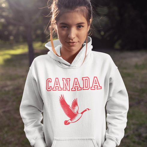 This hoodie celebrates the Canadian goose, wings spread wide, flying across Canada (and probably plotting its next lawn invasion).