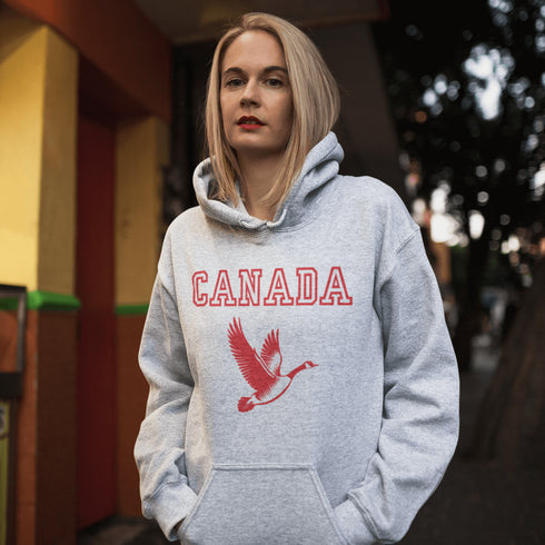 This hoodie celebrates the Canadian goose, wings spread wide, flying across Canada (and probably plotting its next lawn invasion).
