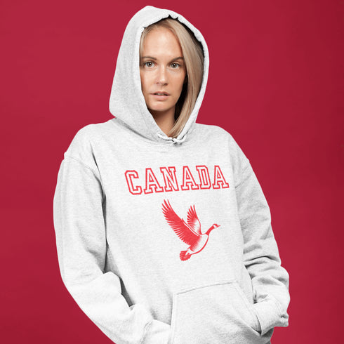 This hoodie celebrates the Canadian goose, wings spread wide, flying across Canada (and probably plotting its next lawn invasion).