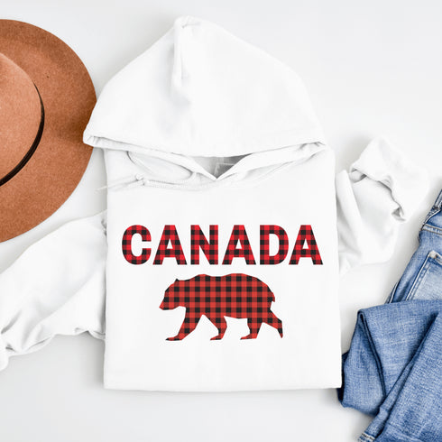 Meet the Plaid & Proud Hoodie, featuring a rugged red & black plaid bear alongside "Canada" in matching plaid lettering—because nothing says “True North strong” like a bear rocking Canadian flannel.