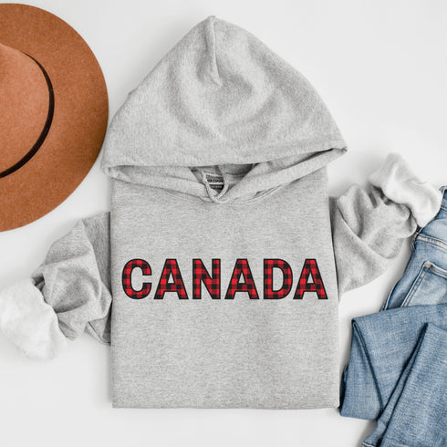 Say hello to the Oh-Canada Hoodie, featuring "Canada" in bold red and black plaid lettering that screams “I’m Canadian, and yes, I’m cozy!”